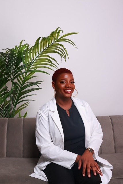 Whitney Johnson seated in a white coat at The Bella Lucy Spa